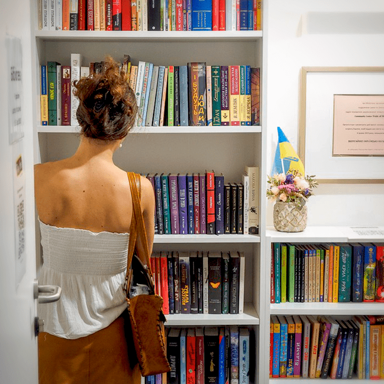 Eine Frau steht vor einem Bücherregal