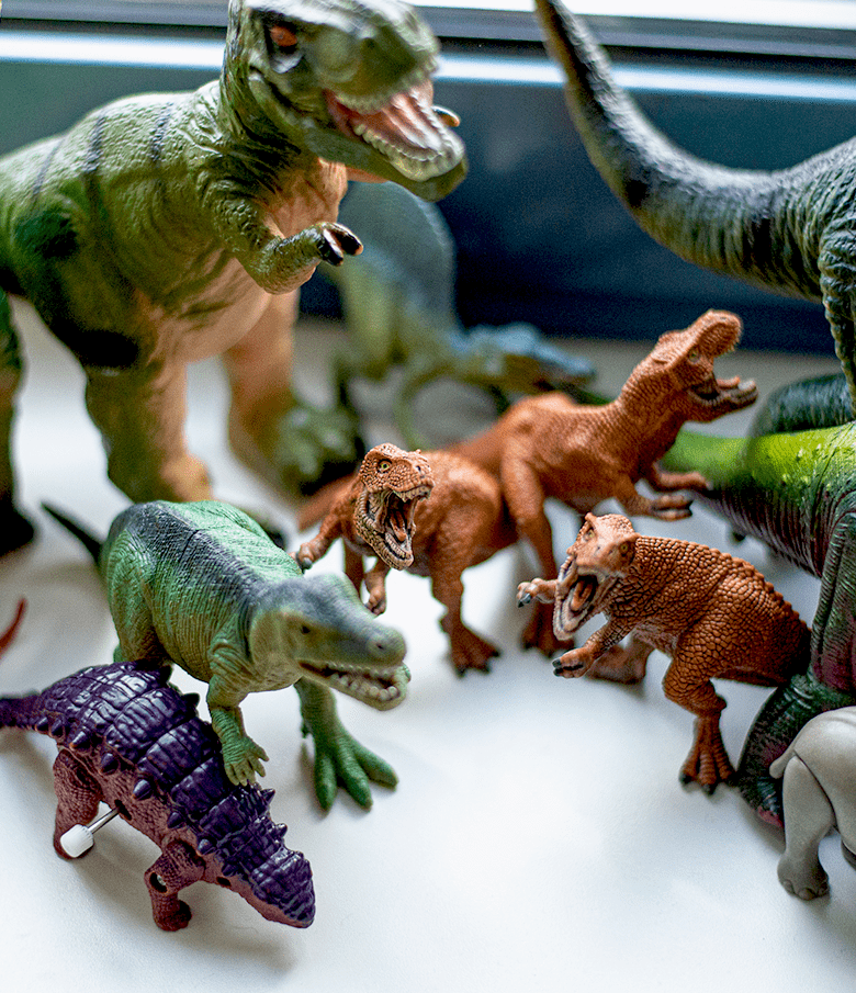 Meherere Spielzeugdinosaurier auf einer Fensterbank