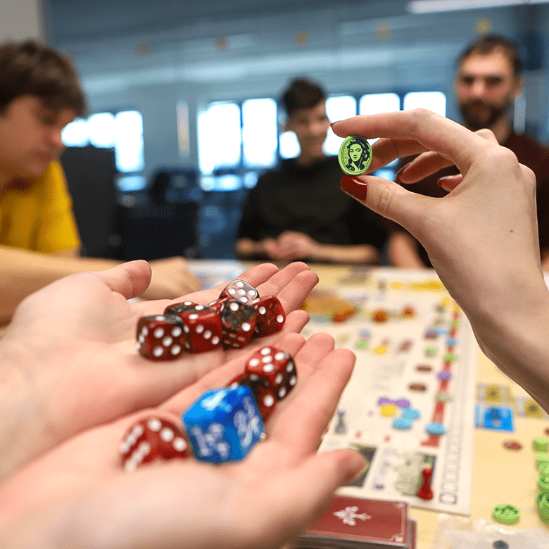 Jugendliche spielen ein Spiel und halten bunte Würfel in den Händen