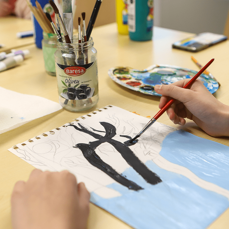 Eine Hand mit einem Pinsel, Farben, ein Bild