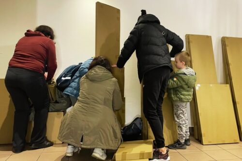 Drei Frauen und ein Kind stehen vor mehreren Paketen mit Möbeln