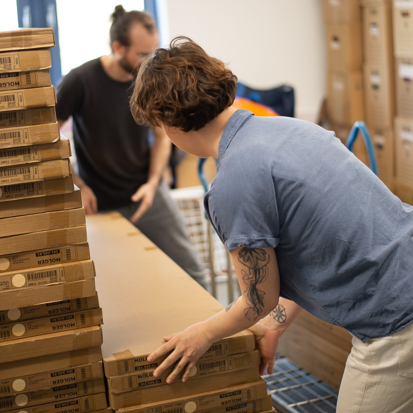 Ein Mann und eine Frau stapeln Kartons mit Möbeln