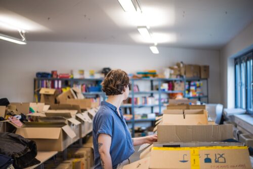 Eine Frau steht neben Tischen mit Kartons